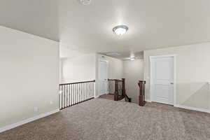 Carpeted spare room featuring a textured ceiling