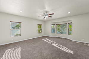 Carpeted empty room with ceiling fan