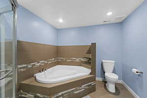 Bathroom with tile patterned flooring, independent shower and bath, and toilet