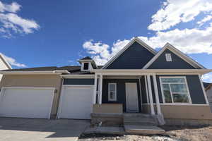 View of front of house featuring a porch, driveway, a garage, and brick siding