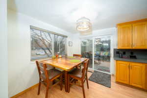 Dining area featuring light wood-type flooring and an inviting chandelier