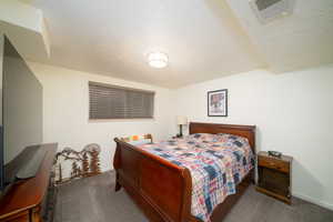 Carpeted bedroom featuring a textured ceiling