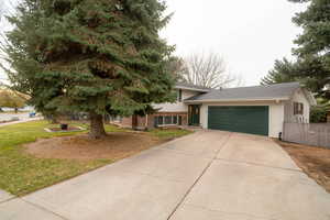 View of front of house with a front yard and a garage