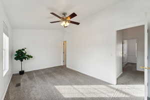 Spare room featuring carpet and ceiling fan