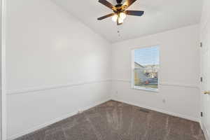 Spare room with carpet, vaulted ceiling, and ceiling fan