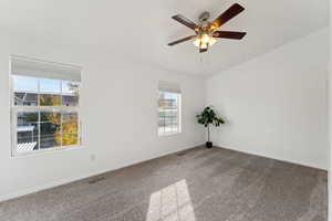 Carpeted spare room with ceiling fan