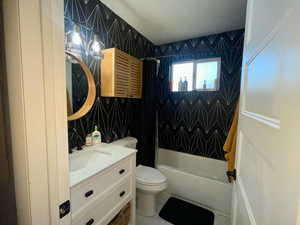 Full bathroom featuring toilet, vanity, shower / tub combo with curtain, and tile walls