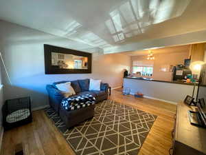 Living room with hardwood / wood-style floors and a notable chandelier