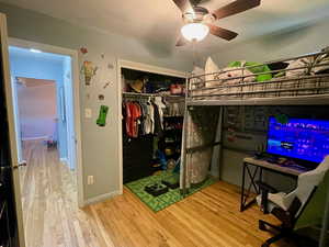 Bedroom with hardwood / wood-style flooring, a closet, and ceiling fan