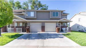 View of front of house featuring a porch, a garage, and a front yard