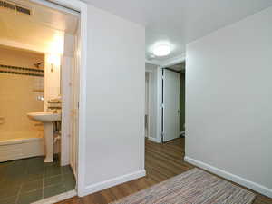 Hallway with dark hardwood / wood-style flooring