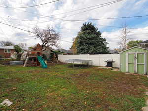 View of yard with a playground and a trampoline