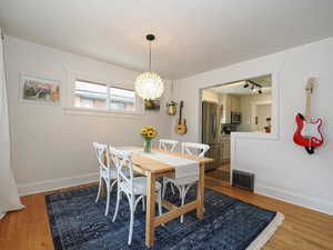 Dining area with a chandelier and hardwood / wood-style flooring