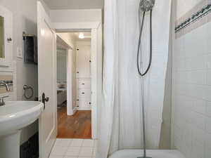 Bathroom with hardwood / wood-style floors and a shower with curtain