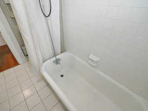 Bathroom with tile patterned flooring and shower / tub combo