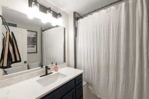 Bathroom with curtained shower and vanity