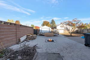 View of yard featuring an outbuilding and a fire pit