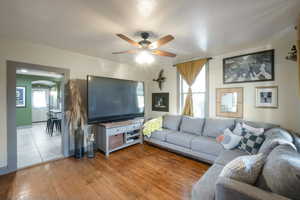 Living room with hardwood / wood-style floors and ceiling fan