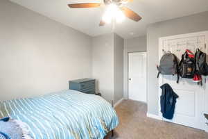 Carpeted bedroom featuring ceiling fan