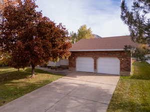 View of front of property featuring a front lawn and a garage