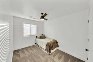 Carpeted bedroom with ceiling fan