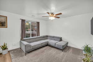 Living room featuring ceiling fan and wood-type flooring