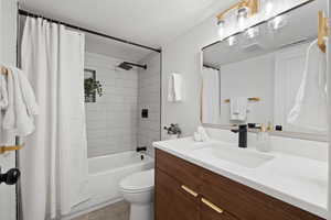 Full bathroom with shower / bath combo, toilet, and vanity