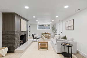 Carpeted living room with a brick fireplace