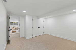 Interior space featuring a closet and light colored carpet