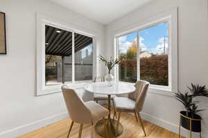 Dining room with hardwood / wood-style floors and a healthy amount of sunlight