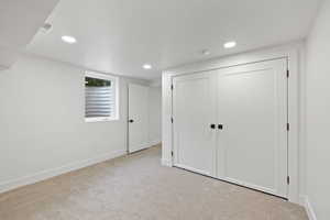 Unfurnished bedroom with light colored carpet and a closet