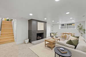 Carpeted living room featuring a brick fireplace