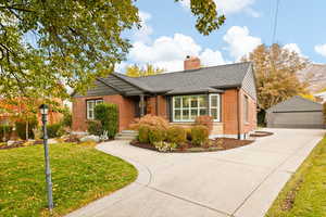 View of front facade with a garage, an outdoor structure, and a front yard