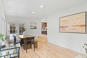 Dining room with french doors and light hardwood / wood-style flooring