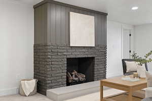 Living room with a fireplace and light colored carpet