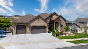 View of front facade featuring a front yard and a garage