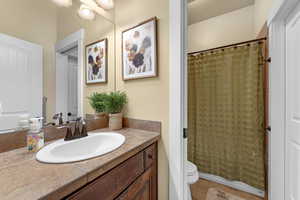 Bathroom featuring toilet, vanity, tile patterned floors, and curtained shower