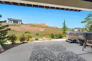 View of patio / terrace with a mountain view and a hot tub