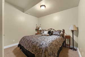 Bedroom featuring light colored carpet and a textured ceiling