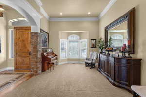 Living area featuring crown molding, plenty of natural light, and wood-type flooring