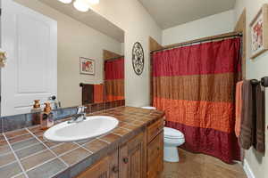 Bathroom featuring tile patterned flooring, vanity, and toilet