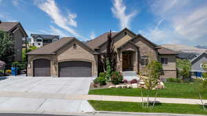 French country inspired facade with a mountain view, a garage, and a front yard