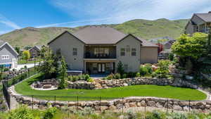 Rear view of house featuring a lawn, a mountain view, a patio area, and a balcony