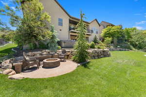 View of yard featuring a patio area, a balcony, and a fire pit