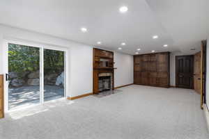 Unfurnished living room featuring a fireplace and light colored carpet