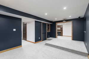 Basement with carpet flooring and a fireplace