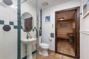 Bathroom with toilet, tile walls, and wooden walls