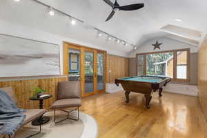 Game room featuring wood walls, light hardwood / wood-style floors, pool table, and vaulted ceiling