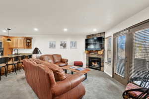 Carpeted living room with a fireplace and sink