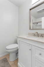 Bathroom with tile patterned flooring, vanity, toilet, and walk in shower